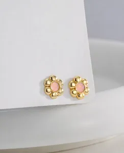Detail of flower stud earrings in 18K gold finish with pink opal resin center