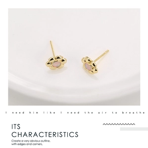 Detailed close-up of small vintage flower earrings in 18k gold with pink opal stone