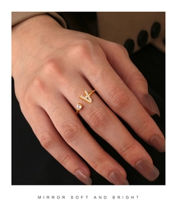 Detailed view of gold plated open ring with cubic zirconia letter A on a finger