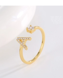 Macro shot of a gold-plated adjustable ring featuring a pavé zircon letter A and clear round stone