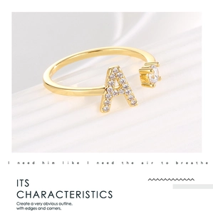 Close-up of 18K gold plated ring with letter A and zircon stone on white surface
