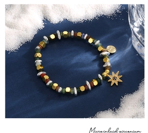 Vista macro del bracciale con perline, ciondolo a stella e zirconi incastonati