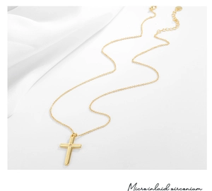 Makro-Detail von goldenem Kreuzanhänger mit Zirkon-Mikro-Inlay und eleganter O-Kette