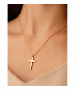 Nahaufnahme einer goldenen Kreuzkette mit O-Kette und Zirkonstein auf Model getragen