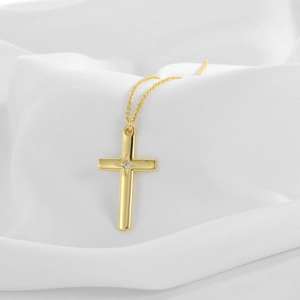 Elegante goldene Kreuzkette mit Zirkonia auf weißem Seidenhintergrund für Damen und Herren