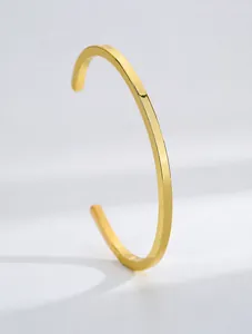 Detail eines minimalistischen, 18 Karat vergoldeten Armreifs im geometrischen Design