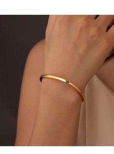 Minimalistischer, 18 Karat vergoldeter offener Armreif am Handgelenk mit Glanzeffekt
