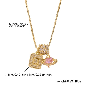 Detail of square letter D pendant with pink heart planet on a gold box chain necklace