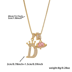 Detail of 18k gold plated letter D pendant with pink heart stone and crown accents