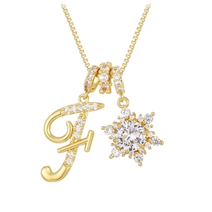 Detail einer goldenen Halskette mit Zirkonia-Buchstaben F und glitzerndem Schneeflocken-Anhänger