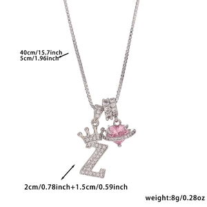 Detail of copper necklace with zircon crown letter Z and pink heart pendant