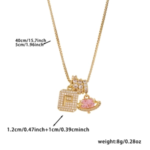 Detail of gold necklace with zircon square letter P, ring and pink planet pendants