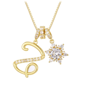 Detailansicht einer Goldkette mit einem Zirkonia-S-Anhänger und einem Schneeflocken-Charme