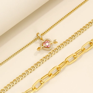 Mehrlagige goldene Herzkette mit rosa Zirkonia-Anhänger und klassischen Gliederketten