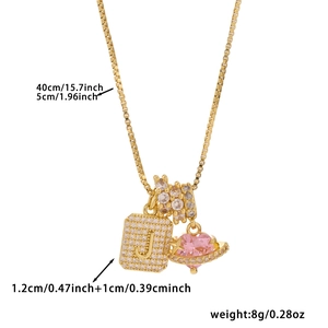 Detail of gold box chain necklace with zircon J pendant, pink heart and dimensions text