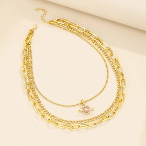 Detailansicht der mehrlagigen Goldkette mit rosa Zirkonia-Herz und Schlangenkette