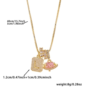 Macro shot of cubic zirconia letter L pendant with pink planet charm and paved ring detail