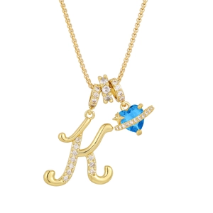 Detail of gold letter K necklace with blue heart gemstone and sparkling star accents