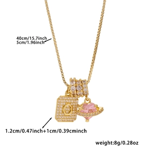 Macro view of gold initial O pendant with zircon cubic stones and pink heart charm