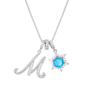 Macro detail of snowflake pendant with blue stone and pavé zircon letter M charm