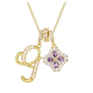 Détail du collier doré avec pendentif lettre G et trèfle en zircone violette