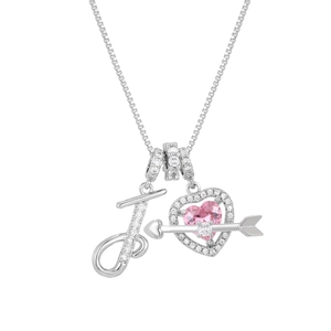 Macro shot of silver letter J and pink heart pendant set with sparkling pave diamonds