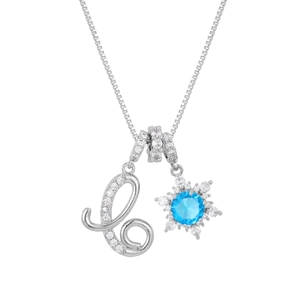 Macro detail of silver snowflake pendant with blue stone and zircon letter L on box chain
