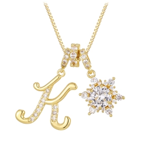 Makroaufnahme Goldhalskette mit Strass-Buchstabe K und Schneeflocken-Anhänger