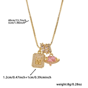 Detail view of gold necklace with letter W pendant, pink heart stone, and size specs