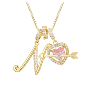 Macro detail of gold letter N pendant with pink zircon heart and cupid arrow