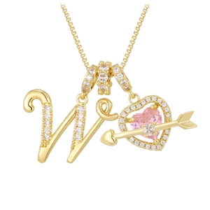 Detailed macro of golden box chain with zircon letter W and pink heart arrow pendant
