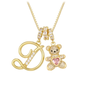 Close-up of gold bear necklace with letter D pendant and pink heart gemstone