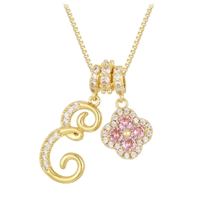 Close-up of gold necklace with zircon G-letter and pink gemstone clover pendants