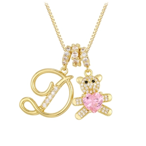 Macro view of gold letter D necklace with a sparkling teddy bear and pink heart gem