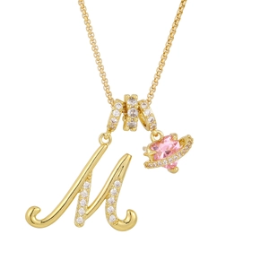 Close-up of gold box chain necklace with letter M and pink heart planet charm