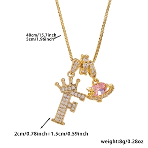 Close-up of golden crown letter F necklace with pink crystal planet pendant dimensions