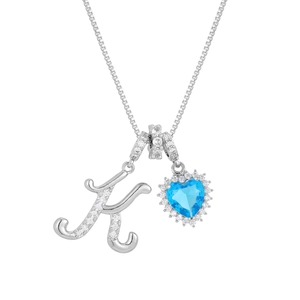 Macro view of silver necklace with blue heart gemstone and zircon-paved K letter