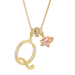 Detail of gold necklace with letter Q pendant and pink heart planet with zircons