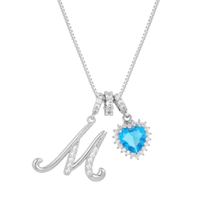 Detail of letter M pendant with a heart-shaped blue gemstone and crystal border