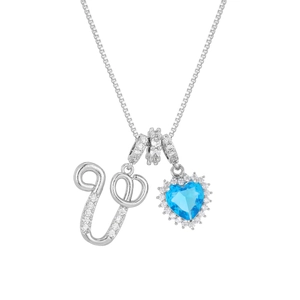 Macro detail of silver box chain with letter U pendant and heart-shaped blue gemstone