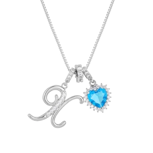 Close-up of silver letter pendant with heart-shaped blue gemstone and micro-pave zircons