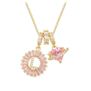 Detalle macro del colgante letra L dorada con gemas rosas y dije de corazón estelar