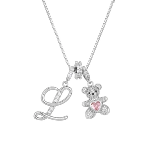 Macro shot of silver teddy bear pendant and crystal encrusted letter L on box chain
