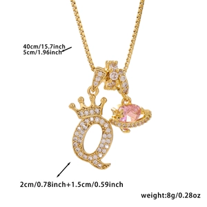 Detail of gold letter Q crown pendant with pink stone planet charm on a delicate chain