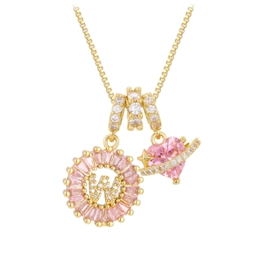 Detalle de cadena box dorada con colgante de corazón rosa y letra W de circonita