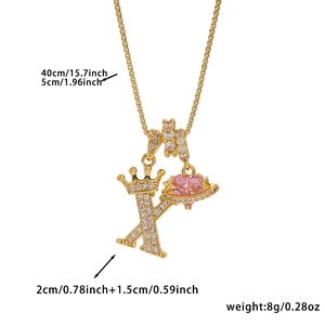 Detail view of gold letter K necklace with pink heart stone and crown dimensions