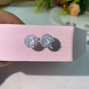 Détail macro de boucles d'oreilles en zircon bleu clair avec cristaux blancs brillants
