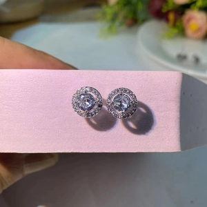 Gros plan de boucles d'oreilles halo rondes argentées serties de zircons cubiques