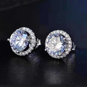 Vue macro de boucles d'oreilles halo en argent avec zircon brillant et entourage pavé