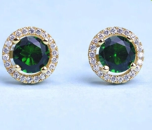Vue détaillée des boucles d'oreilles halo avec pierres vertes et finition dorée